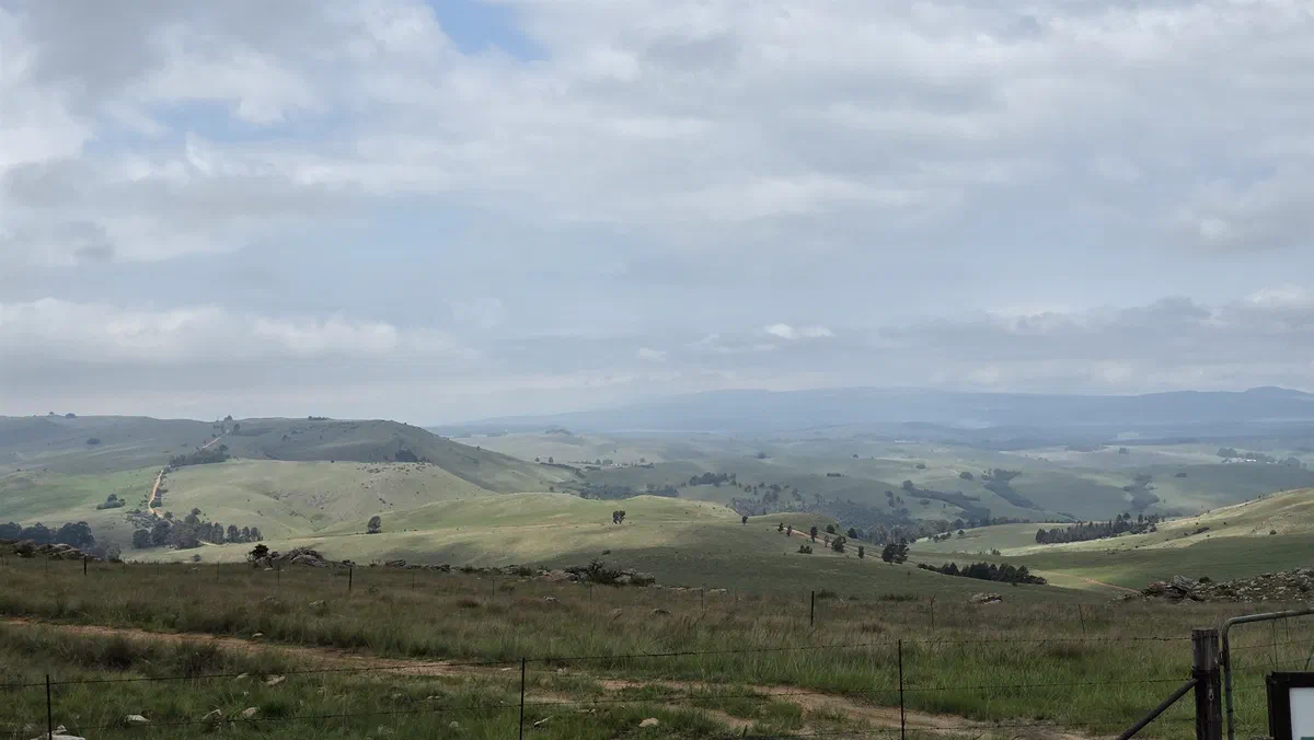 Rolling hills and farmland under a cloudy sky