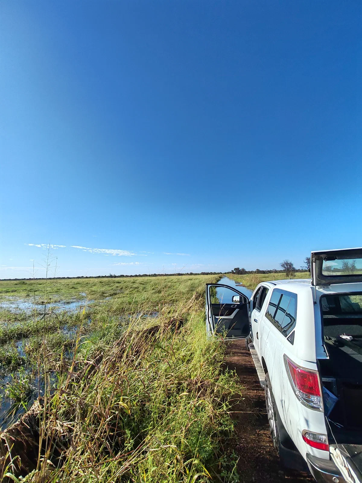 The vehicle parked beside a flooded grassland